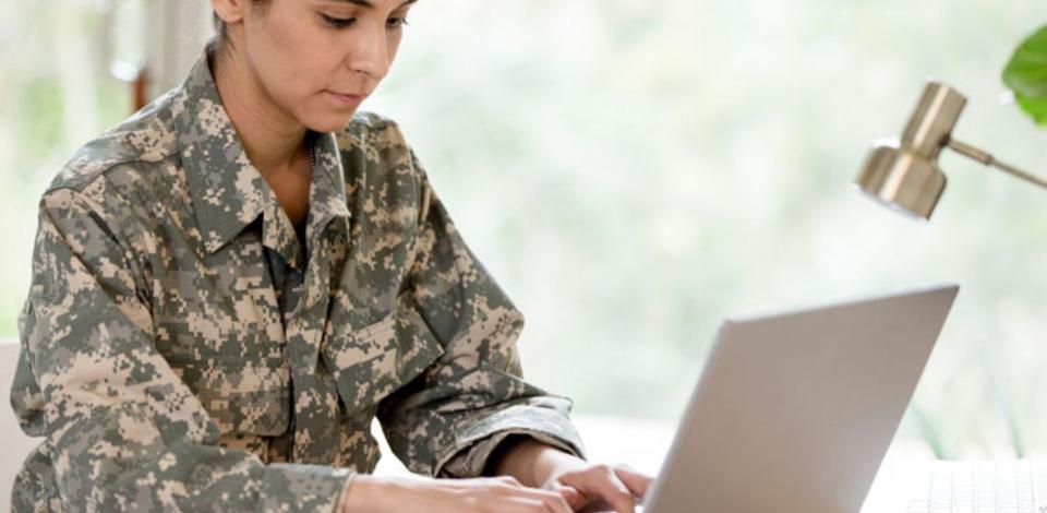Female solider learning on laptop
